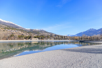 A scenics view of the Embrun, France lake with snowy mountains range in the background under a...