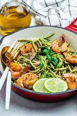 Zucchini spaghetti with pesto sauce and grilled shrimp skewers in pan. keto low carb diet. banner, menu, recipe place for text, top view