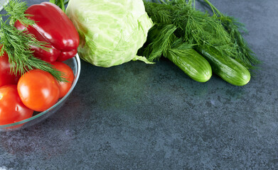 Cabbage with cucumbers, tomatoes, red bell peppers and dill on the kitchen table, top view. Vegetables for the salad.