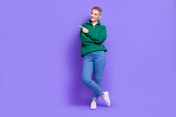Naklejka premium Full length photo of pretty dreamy woman dressed green pullover looking showing finger empty space isolated purple color background