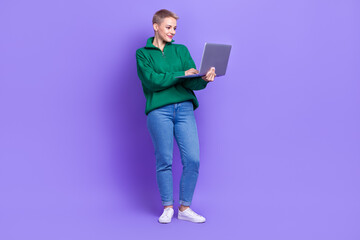 Full length photo of pretty positive lady wear green sweater communicating modern device isolated violet color background