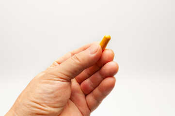 Man hand holding Turmeric supplement capsule isolated on white background with copy space