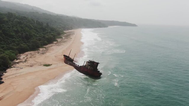 long west african coast line with an abandoned shipwreck stranded on the beach in Robertsport, Liberia