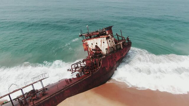 a stranded oil tanker rusting on a beach
