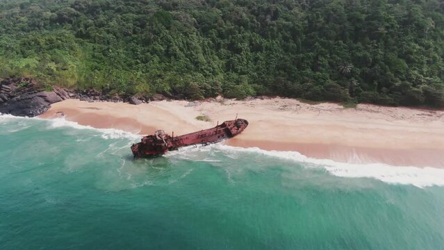 waves crashing into the abandoned shipwreck of an oil tanker at the coast of west africa