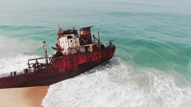 waves crashing into the bridge of an abandoned shipwreck of an oil tanker on the West African coast