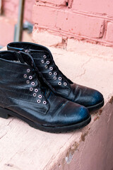 Old black discarded boots in a landfill