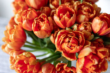 Large bouquet of orange tulips in a vase, top view.