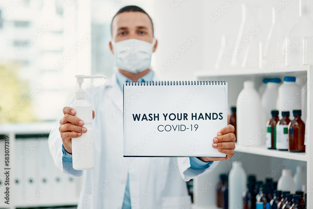 Poster keep your hands clean. a scientist holding a sign with wash your hands on it and hand sanitiser in a