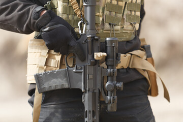 Ukrainian soldier equipped with modern American assault rifle with optical scope. Military training at the shooting range.