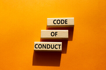 Code of conduct symbol. Wooden blocks with words Code of conduct. Beautiful orange background....