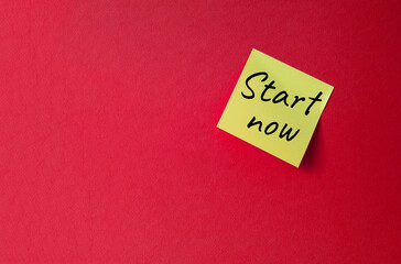 Start now symbol. Orange steaky note with words Start now. Beautiful red background. Business and Start now concept. Copy space.