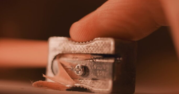 Sharpening a pencil with metal sharpener - close up