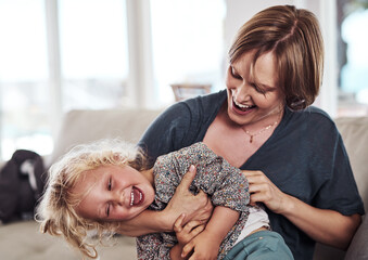 Ive got you now. an attractive young mother sitting and tickling her daughter during a day at home. - obrazy, fototapety, plakaty