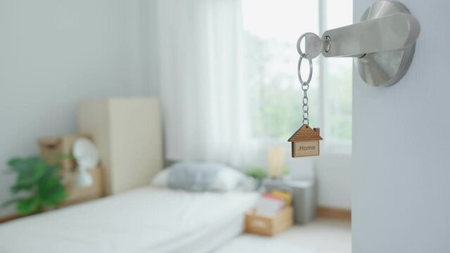 Moving house, relocation. The key was inserted into the door of the new house, inside the room was a cardboard box containing personal belongings and furniture. move in the apartment or condominium
