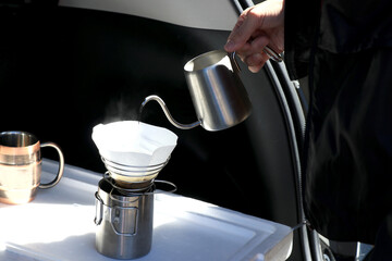 屋外でコーヒーを淹れる人の手元　キャンプイメージ