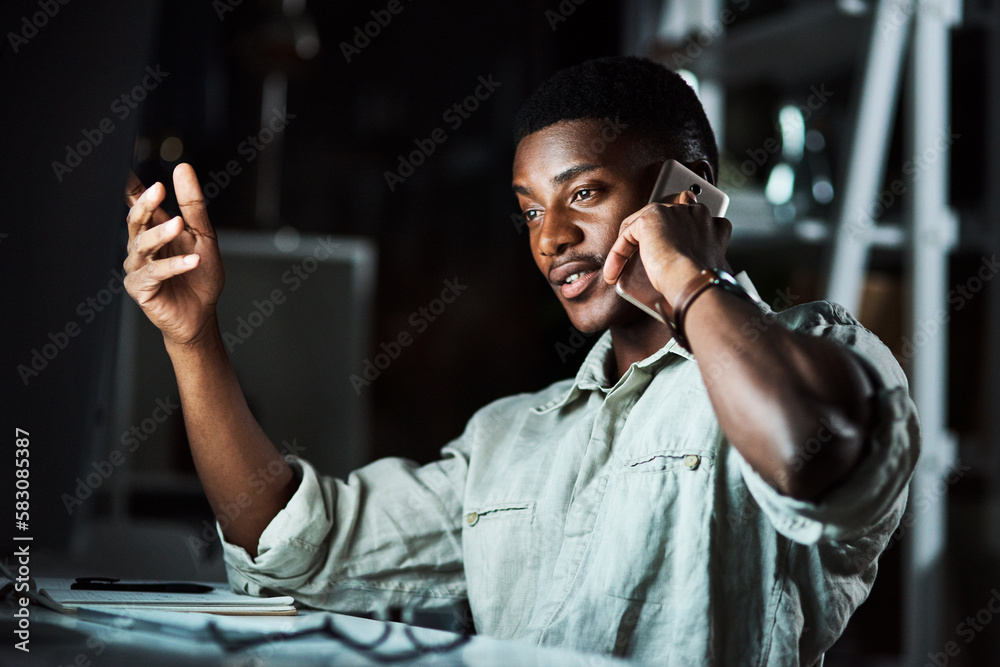 Poster making some last minute calls. a businessman talking on his cellphone while working late at the offi