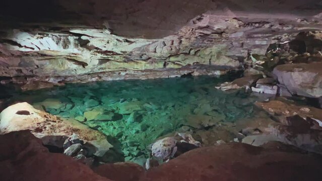 Excursion to the dark ice cave in winter. Underground large stone cave with lakes. Tourism in Russia, the concept of speleology. Kungur ice cave. Perm Region. Underground lakes caves. 4K