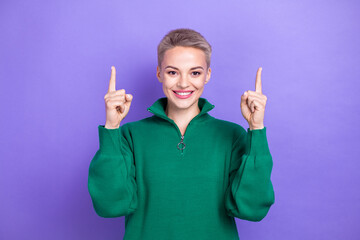 Photo of optimistic satisfied charming blonde short hair women direct fingers up empty space breaking news media isolated on violet color background