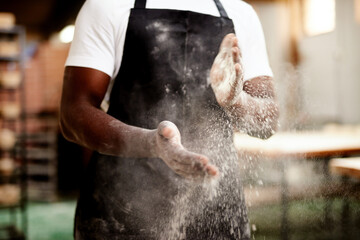 Done and dusted. an unrecognizable male baker dusting the flour off his hands.