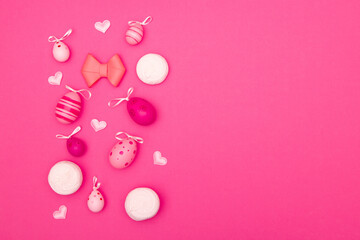 Obraz na płótnie Canvas Easter background in pink with eggs, hearts, marshmallows and bow makes for a perfect Easter-themed copy space