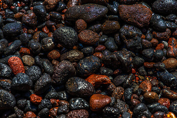 black and red volcano beach stones in Santorini, Greece