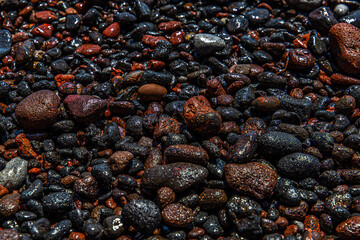 black and red volcano beach stones in Santorini, Greece