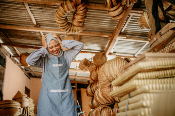 stress young worker while standing at her warehouse holding her head