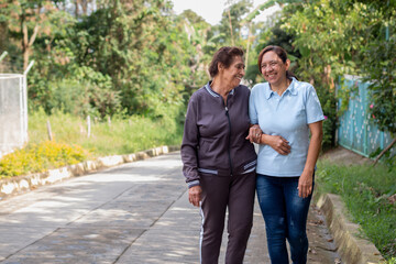 Elderly mother and daughter share a joyful moment during a morning walk in the morning.