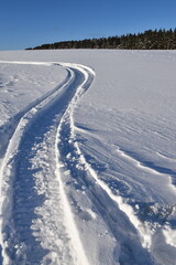 Fototapeta na wymiar A snowmobile trail in a field, Québec, Canada
