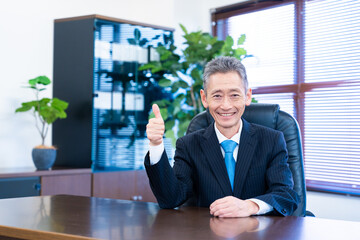 グッドサインをする経営者