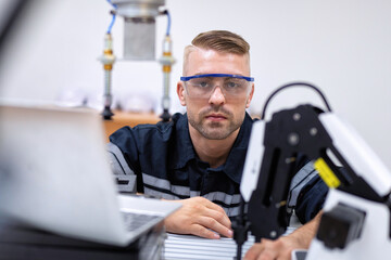 Fototapeta na wymiar Engineer sitting in robot fabrication room quality checking robot arm hardware engineering