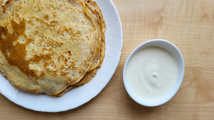 Fried pancakes with sour cream on the table to the Butter dish.