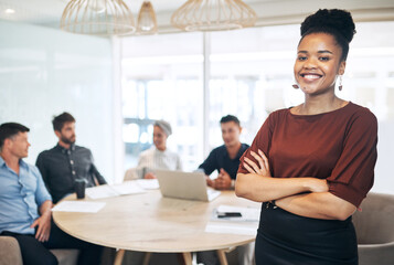 You have to hold great confidence if you want to succeed. Portrait of a young businesswoman standing in an office with her colleagues in the background.