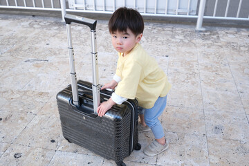 スーツケースを押す男の子　旅行イメージ