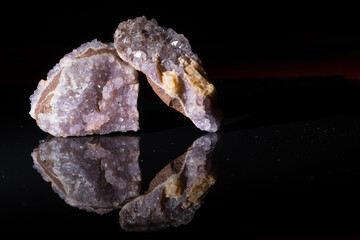 Amethyst mineral with crystals with reflection on a black background.