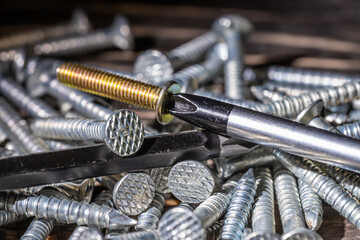 Screws and screws on the table in a pile of close-up.