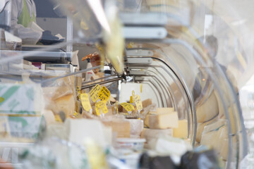 Display of fresh cheeses at a street market in the Veneto region, with people buying and exploring the local flavors, Italy