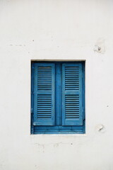Fototapeta na wymiar Blue window shutters on white wall