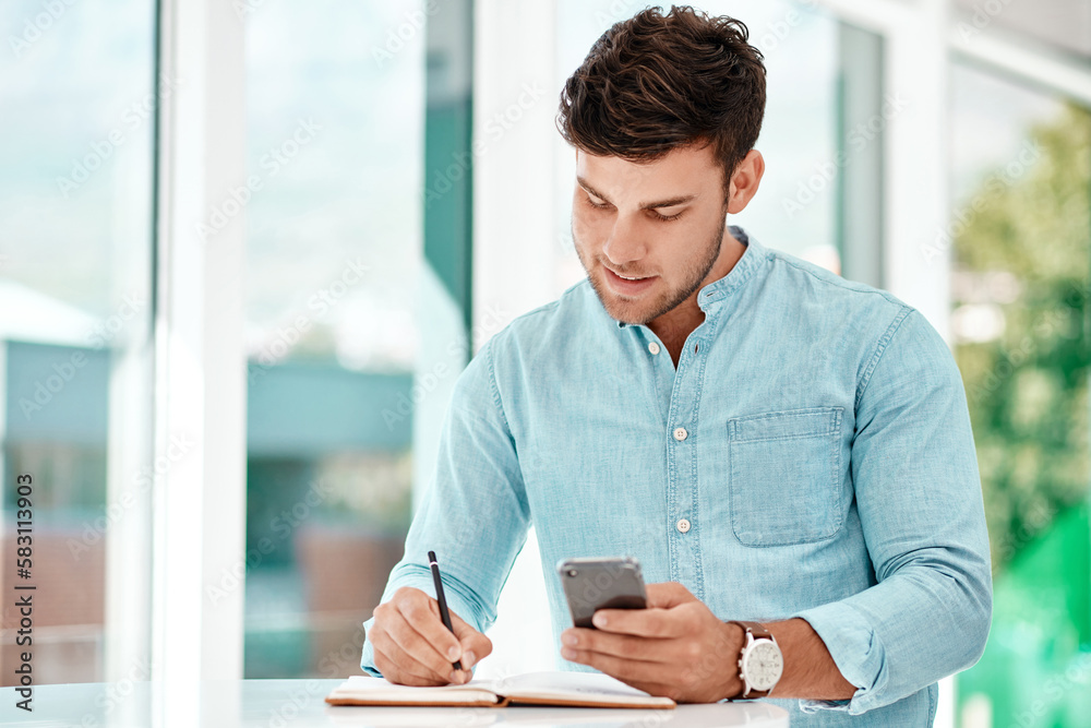 Aufkleber making notes helps him improve. a handsome young businessman making notes while siting at a table in