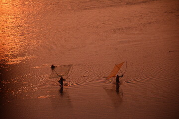 bamboo poles and dotting fishermen blend into the mudflats as the sun rises in Xiapu, Fujian, China