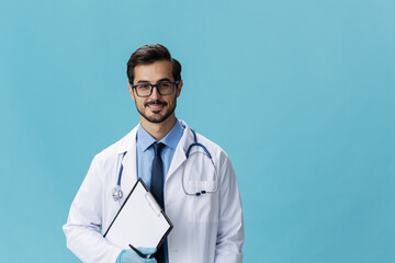 Male doctor in a white coat and glasses with a medical record on a blue isolated background, copy space, space for text