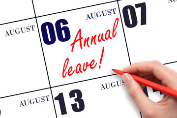 6th day of August. Hand writing the text ANNUAL LEAVE and drawing the sun on the calendar date August 6. Save the date. Time for the holidays. vacation calendar. Summer month, day of the year.