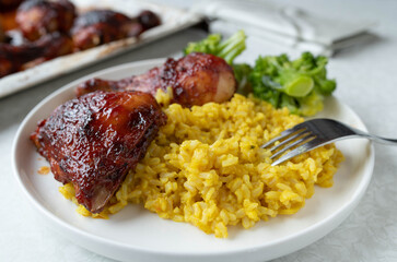 Pilau rice with glazed chicken and broccoli on a plate