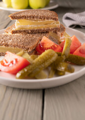 Harzer cheese sandwich with pickles and tomatoes on a plate