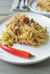 Pasta with tuna, garlic, chili, olive oil and parsley. Traditional italian cuisine Noodles aglio e olio on plate