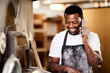 Ill make your lunchtime real special with a fresh delivery. a male baker using his cellphone while...