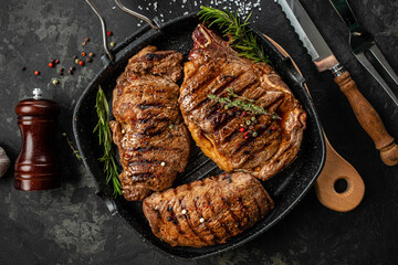three beef steaks with grilled spices on a stone background. Restaurant menu, dieting, cookbook recipe top view.