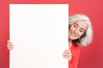 Woman looking at the white board that she is holding