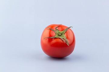 Fresh tomato on blue background.